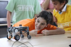 חניכה במחנה קיץ בישראל מסתכלת על רובוט שיצרה